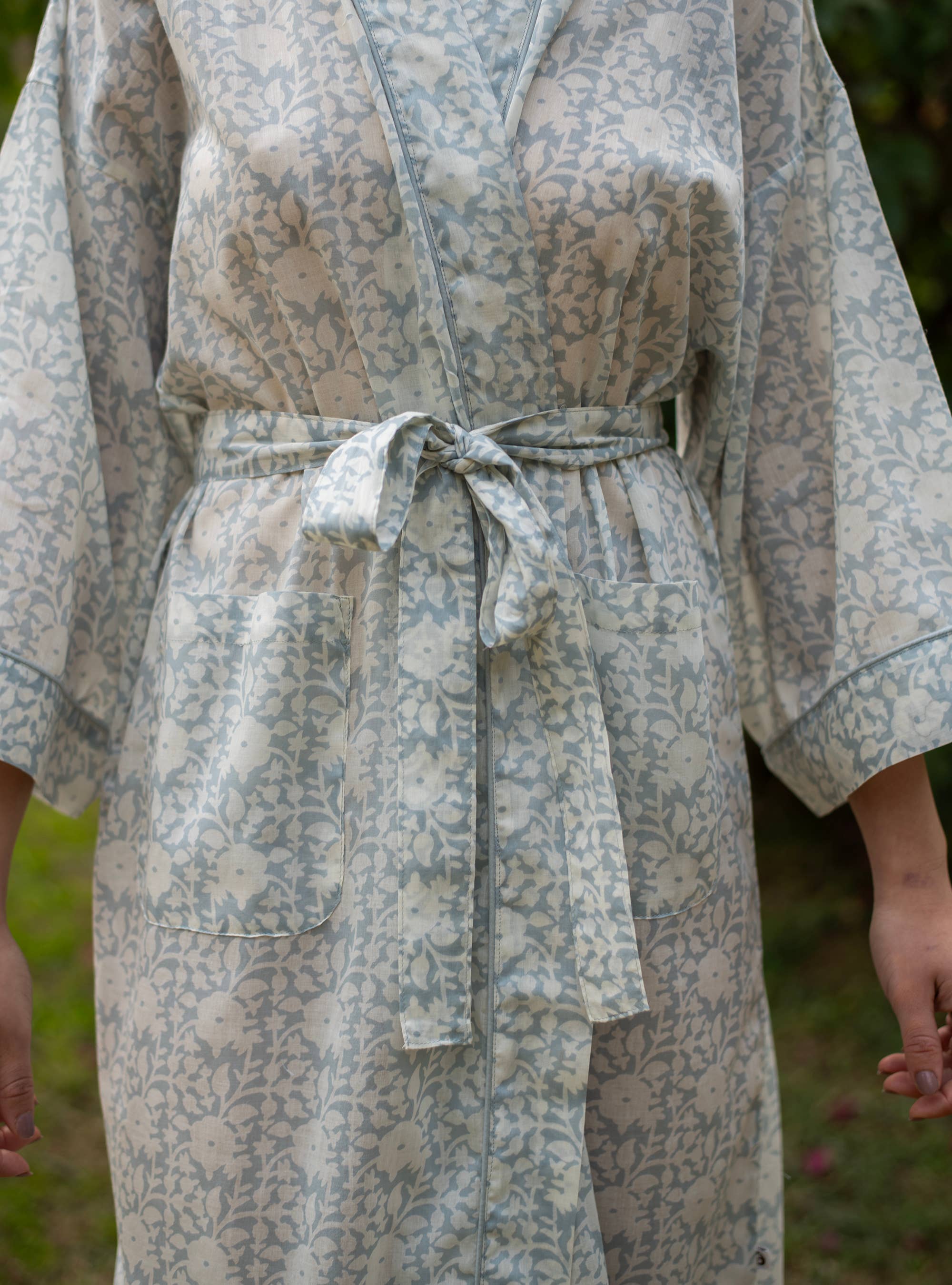 Person wearing a floral-patterned robe outdoors